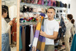 © JackF - Pleased young boy choosing colored scarf in clothing store with large assortment