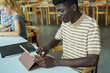 © Sabrina - Young african student learning inside school classroom using digital tablet - University, college and education concept
