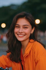 Poster - close-up of laughing young latina woman leaning on handlebars trees and streetlights softly blurred behind
