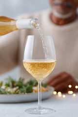 Poster - close-up of elderly south asian man pouring wine for guest at home dinner soft table lights and bokeh