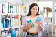 © JackF - Young woman buyer chooses bottle of mouthwash in household chemicals store..