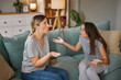 © Stockphotodirectors - A teen girl and her mother are engaged in a heated conversation on a couch, expressing frustration and emotions about everyday challenges and expectations in their relationship.