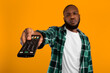 © Prostock-studio - Bored African American Man Switching Channels Pointing Television Controller To Camera Watching Boring TV Program Posing On Yellow Studio Background. Discontented Televiewer. Selective Focus