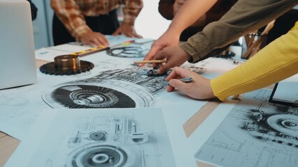 Poster - A dynamic team of professionals engages in a collaborative discussion around a table filled with technical drawings, tools, and design plans, showcasing creative teamwork. SACTR