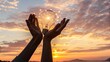 © BELAL - Hands holding a glowing light bulb filled with fairy lights at sunset