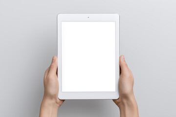 Poster - Hands holding a tablet with a blank screen, showcasing a minimalist design against a soft gray background, ideal for digital mockup presentations and creative projects