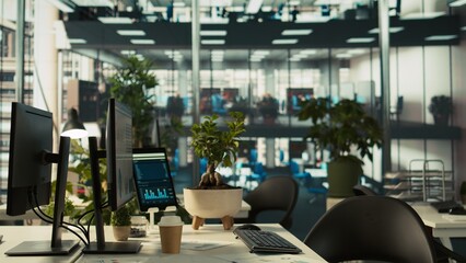 Poster - Business graphs and performance metrics on monitors in workplace, handheld camera shot. Office desk setup in bright corporate environment with monitors displaying data analytics, panning shot