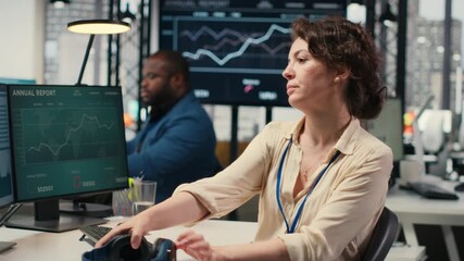 Poster - Young businesswoman focused on a podcast while she resolves office tasks, monitoring insights or KPI metrics on pc. Strategy reports for expansion plans with digital tools. Camera B.