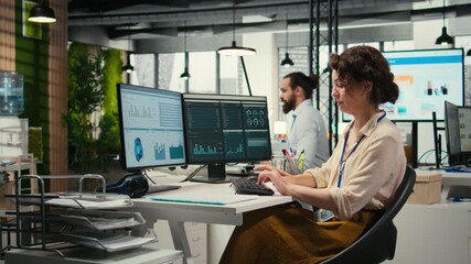 Poster - Female employee in a high end office analyzing performance metrics and business strategy on computer monitor, focusing on report writing and planning to drive results and success. Camera A.