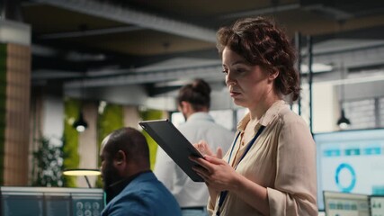 Poster - Pensive woman business leader does forecasting on her tablet in the office, working in a multinational company. Specialist using data analytics and insights for a development vision. Camera B.