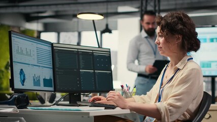 Poster - Administrator engages with financial data insights on a computer, developing innovative business solutions and aligning project goals with company objectives. Corporate environment. Camera B.