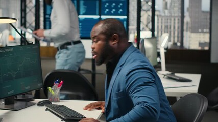 Poster - African american man with a stiff neck and backache stretching his muscles, correcting his bad posture while he works on business tasks. Focusing on organizational success. Camera B.