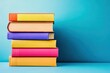 © Meenaxi - Vibrant Stack of Colorful Books on a Modern Blue Background in a Minimalist Composition