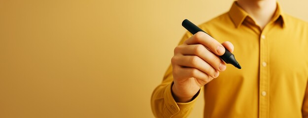 Poster - Man in yellow shirt holding black marker with copyspace on yellow background for business promotion or advertising banner design template.