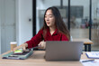 © SOMKID - feeling stressed asian businesswoman working on laptop sitting at desk in modern office space for work online.