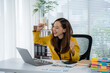 © Kritdanai - Triumphant Entrepreneur at Desk: A spirited businesswoman celebrates a professional triumph in her sunlit office, her laptop and office supplies as background.