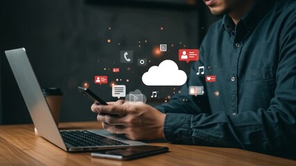 Man on phone at laptop with cloud graphic icons