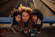 © bernardbodo - Three young friends leaning on a bridge railing looking down