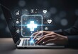 © senyumanmu - Hands typing on a laptop with glowing health icons