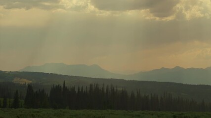 Wall Mural - light shadow on a cloudy sky over mountains during rainstorm. timelapse