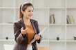 © SOMKID - young businesswoman holding a folder standing in office work.