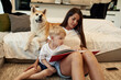 © standret - Reading the book. Mother with son and Shibu Inu dog are at home