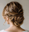 © Jarmila - Back view of woman with light brown hair styled in elegant low chignon with loose waves, ideal for bridal, formal event or hairstyle inspiration