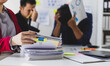 © Wasan - Stressed business team suffering headache and migraine in office meeting, stress from work overload, burnout syndrome, and frustration.