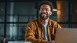 © Ammad - A warm genuine smile from a young professional working late radiating confidence and joy in a modern office with soft