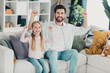 © deagreez - Happy father and daughter bonding at home sitting on sofa and enjoying cheerful moments together