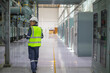 © JD Studio - Power station staff working in industrial facility wearing safety helmet and reflective vest inspecting electrical equipment in clean environment