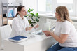 © New Africa - Weight loss. Nutritionist consulting overweight woman at white desk in clinic