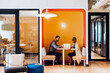 © (JLco) Julia Amaral - Two professionals discussing work in cozy office seating area