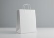 © Shamim Akhtar - Plain white paper shopping bag with twisted handles on a white surface