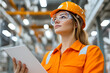 © A2Z AI  - Female engineer in safety gear looking up in a factory. She holds a document and wears a hard hat and safety goggles in an industrial setting.