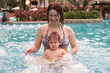 © Михаил Решетников - Caucasian woman holds her son while swimming in a pool on vacation. Mom teaches little boy to swim.
