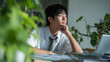 © bephoto - 男子学生が資料を見ながら考える