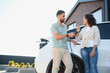 © Serhii - Couple charging electric car at home, embracing green energy and sustainability
