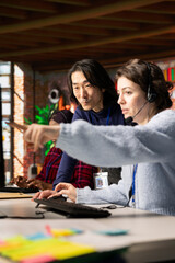 Poster - Experienced call center onboarding specialist providing training to woman on how to use PC tools. Asian senior manager in customer support department office showing intern how to use company platforms
