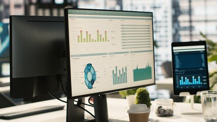 Poster - Financial charts and KPI metrics on displays in office, panning shot. Vibrant and collaborative modern workspace with computer screens displaying data analytics, close up shot