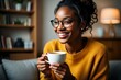 © Focus Gem - Smiling woman enjoying coffee break at home wearing glasses and yellow sweater relax