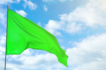 Wall Mural - green flag waving against blue sky outdoors