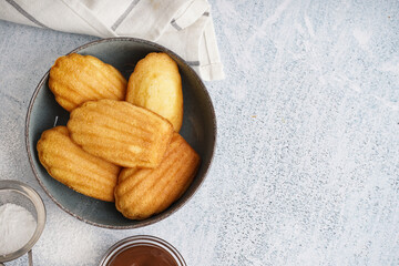 Wall Mural - Bowl with delicious madeleines on white grunge background
