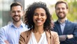 © Wafi - Three smiling business professionals, a woman in the center, stand confidently outdoors