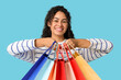 © Pixel-Shot - Happy young African-American woman with shopping bags on blue background