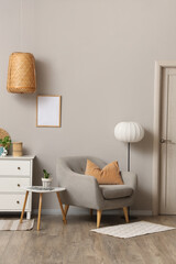 Wall Mural - Comfortable armchair with white chest of drawers and floor lamp near grey wall in living room