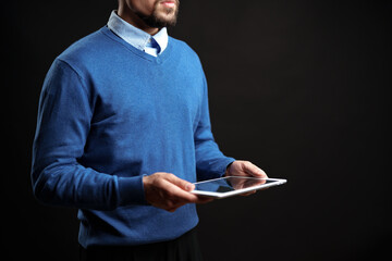 Poster - Man holding tablet in a studio setting during a creative session in the early evening