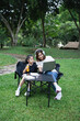 © WMSTUDIO - Woman and Girl Enjoying Quality Time Outdoors while Using Laptop and Listening to Music with Headphones in a Park Setting