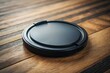© Sajib - Black lens cap resting on a textured wooden surface