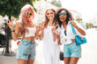 © halayalex - Three young beautiful smiling hipster female in trendy summer clothes.Sexy carefree multiracial women posing on the street background.Positive models having fun in sunglasses. They show peace sign